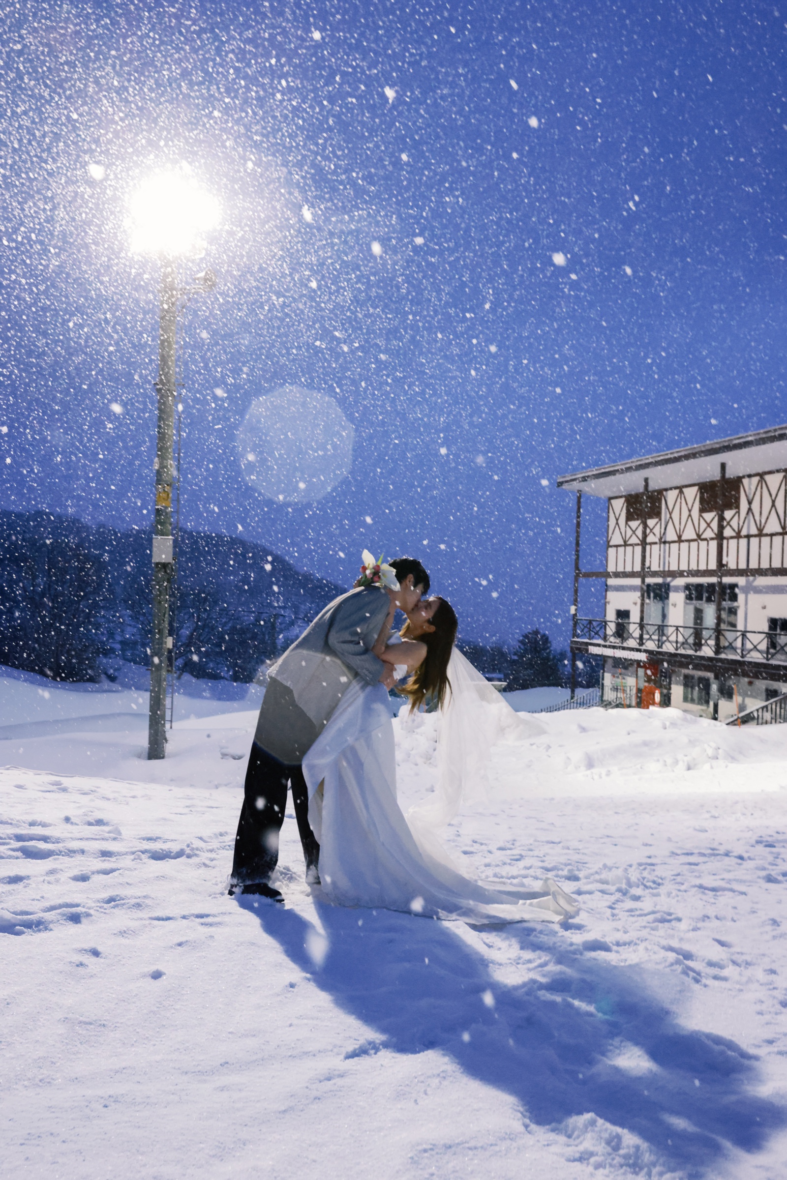 北海道雪夜路灯下拥抱的恋人婚纱照