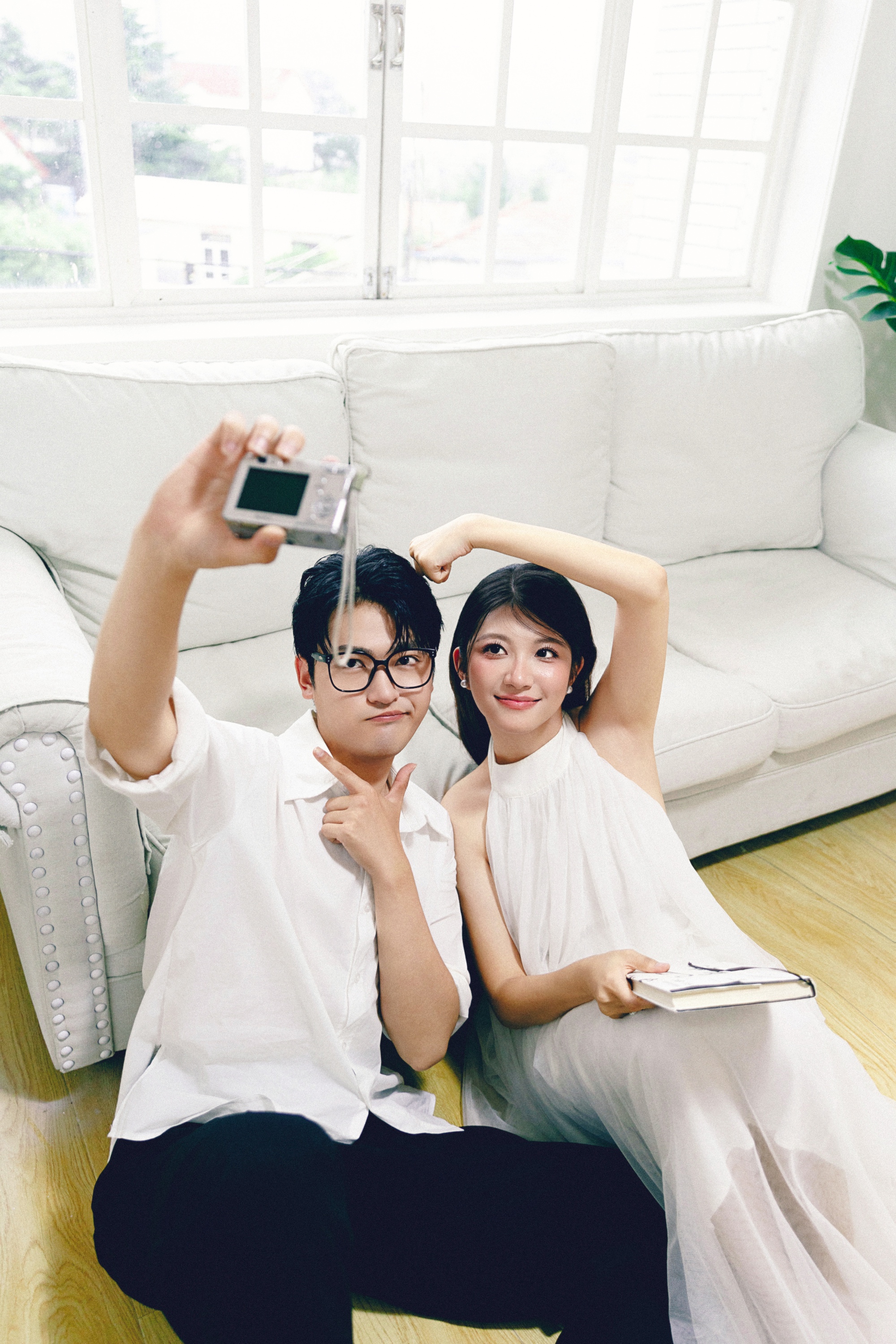 沙发上举起小相机的两个人