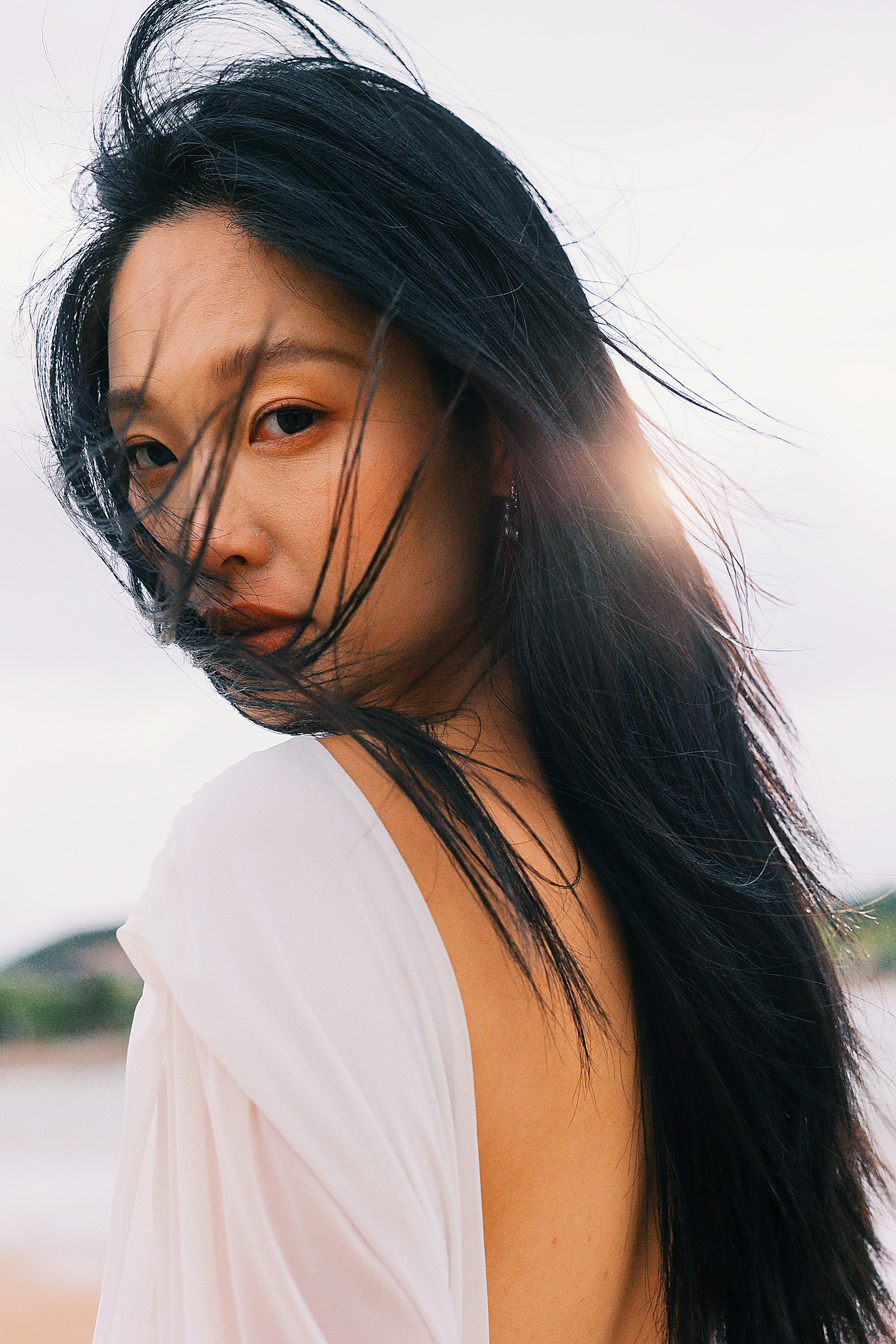 青岛海边白色礼服女子的风中近景
